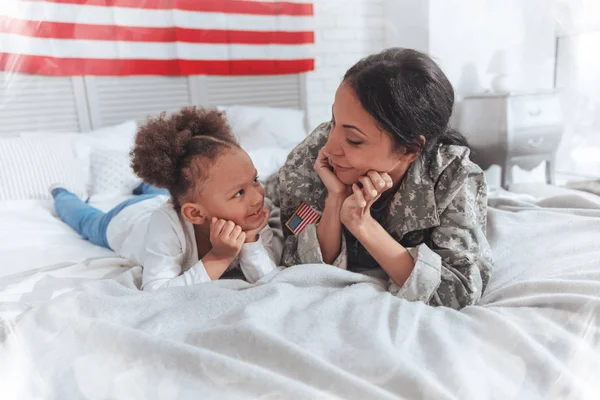 Vrolijke positieve moeder en op het bed liggen — Stockfoto