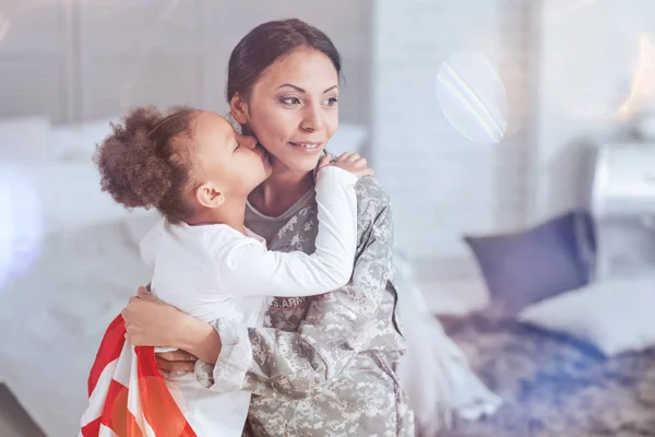 Cute pleasant girl kissing her mother in the neck — Stock Photo, Image