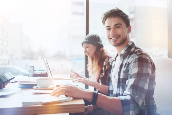 Attraktiver junger Mann, der in der Nähe seiner Mitschülerin sitzt — Stockfoto