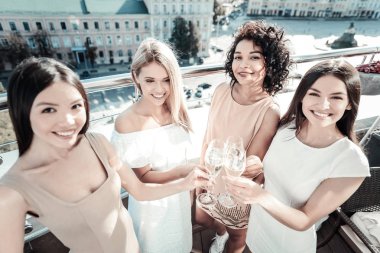 Kadehler tutmak ve gülümseyen genç ve güzel kızlar.