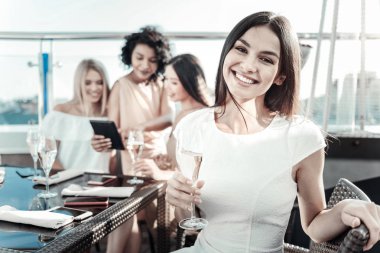 Kadehi tutmak ve gülümseyen güzel neşeli kız.