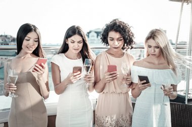 Mesajlaşma ve kadehlerde şampanya tutmak yakışıklı şirin kızlar.