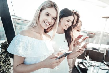 Cep telefonu tutmak ve gülümseyen güzel güzel kız.