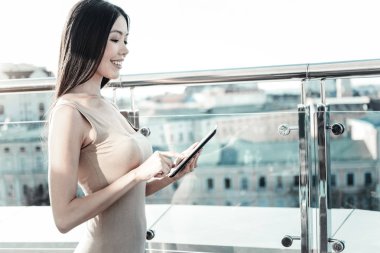 Ayakta ve tablet kullanma akıllı sevimli Bayan.