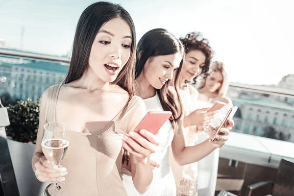 Chicas bonitas con estilo manteniendo teléfonos inteligentes y mensajes . — Foto de Stock