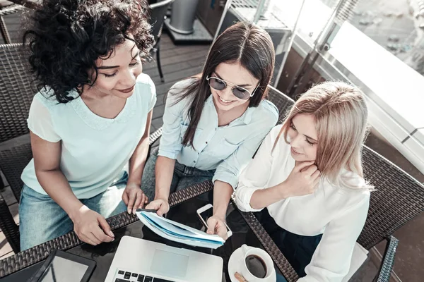 Vriendelijk aangenaam meisjes glimlachend en werken met de laptop. — Stockfoto