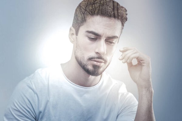 Serious male person looking downwards