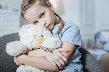 Yalnız kız onun oyuncak ayı sarılma