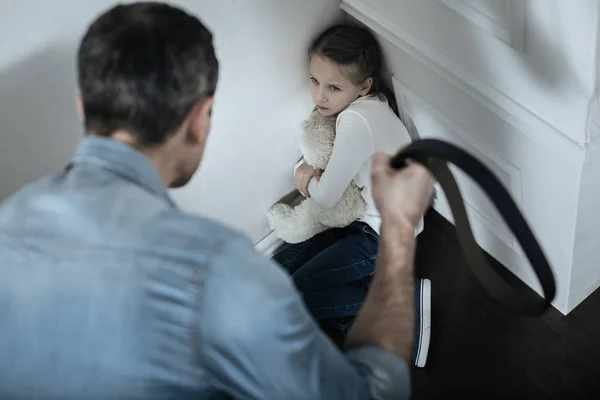 Verängstigtes Mädchen sitzt mit Teddybär in der Ecke — Stockfoto