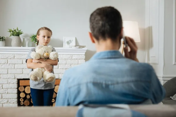 Criança miserável assistindo seu pai falando ao telefone — Fotografia de Stock