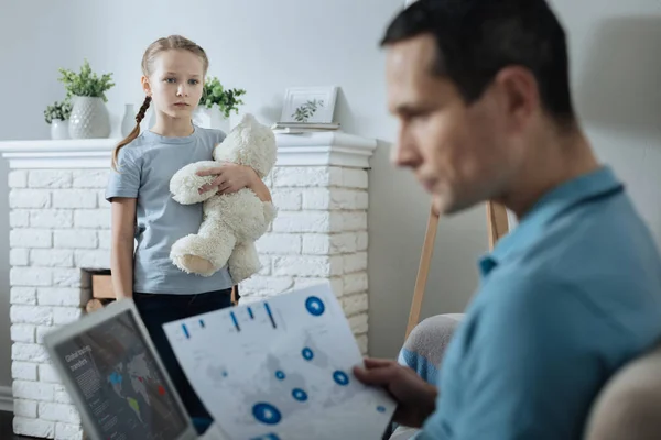 Menina triste assistindo seu pai trabalhando — Fotografia de Stock