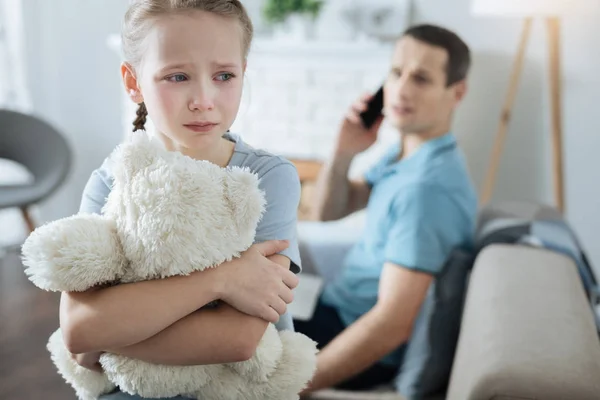 Miserable niña llorando y sosteniendo su juguete — Foto de Stock