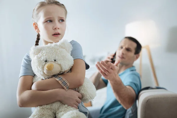 Miserable niña llorando y sosteniendo su juguete — Foto de Stock