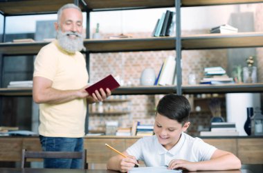 Neşeli dedesi ev işte çalışmak çocuk bakarak