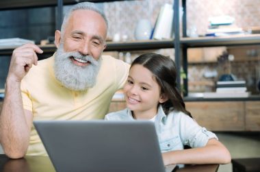 Birlikte laptop kullanarak aile neşeli iki kuşak