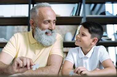 Dost canlısı yaşlı adam ve parçalı bulmaca oyun torunu