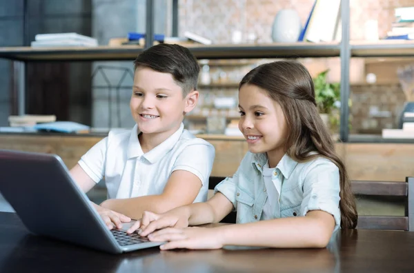 Chytré děti radostné společné používání notebooku — Stock fotografie