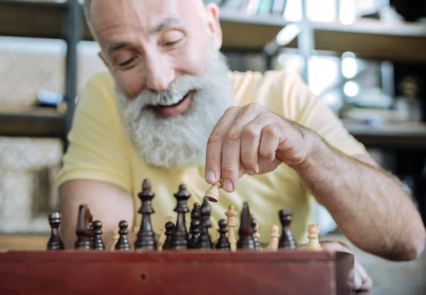 Extremely happy senior man playing chess at home — Stock Photo, Image