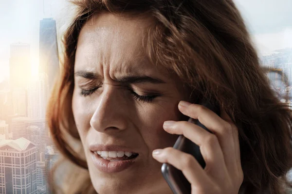 Unhappy woman talking on phone