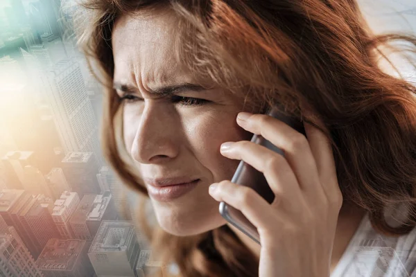 Close up of a depressed woman talking on phone — Stock Photo, Image