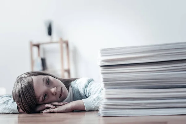 Unhappy girl looking at pile of documents — Stock Photo, Image