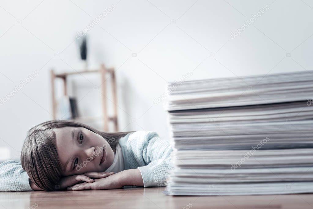 Unhappy girl looking at pile of documents
