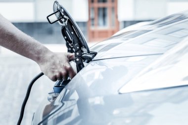 Erkek el elektrikli otomobil meme şarj tutarak yakın çekim