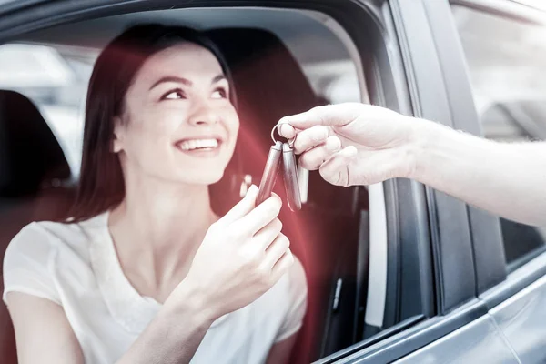 Ακτινοβόλο χιλιετή κορίτσι λαμβάνει τα κλειδιά του αυτοκινήτου από τον άνθρωπο — Φωτογραφία Αρχείου