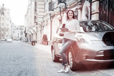 Neşeli bin yıllık Bayan onun araba şarj etmek için bekliyor