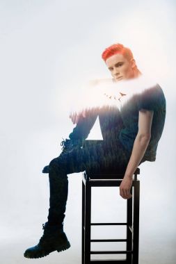 Oturan ve sağ bacağı eğilerek sorumlu konsantre adam.