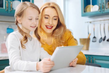 Gülümseyen anne ve kızı tablet kullanma