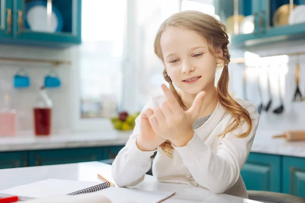 Vrolijke schoolmeisje tellen op haar vingers — Stockfoto