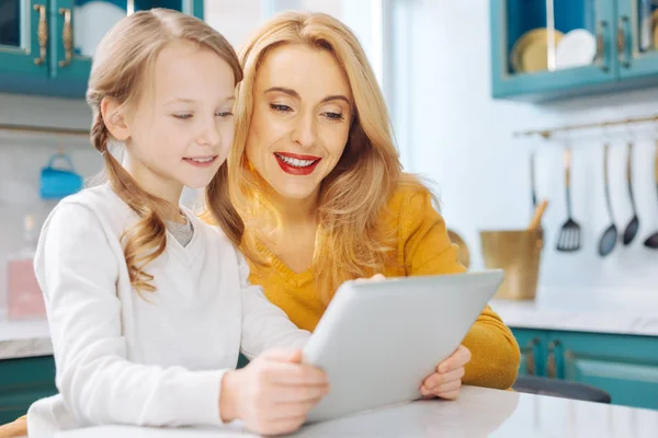 Smiling mother and daughter using a tablet