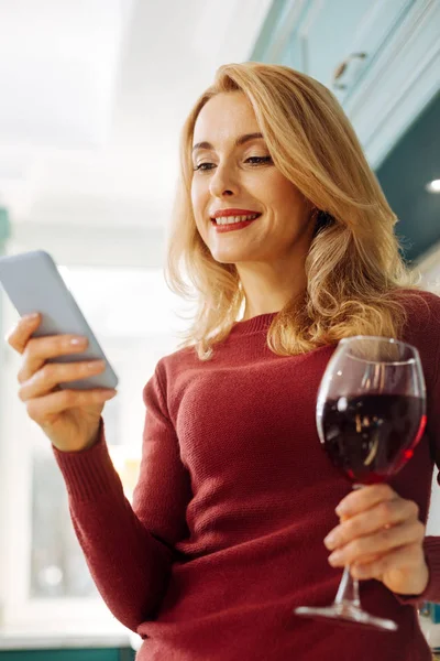Вдохновлённая печатанием на телефоне и питьем вина — стоковое фото