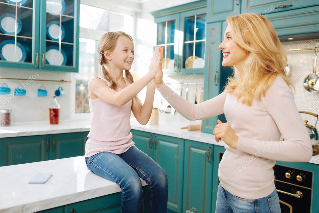 Smiling mother and daughter giving a high-five
