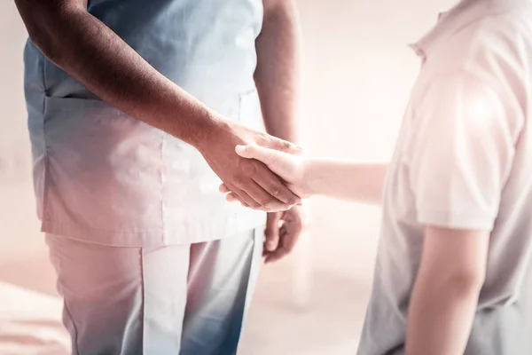 Primer plano del trabajador médico y del niño estrechando las manos — Foto de Stock