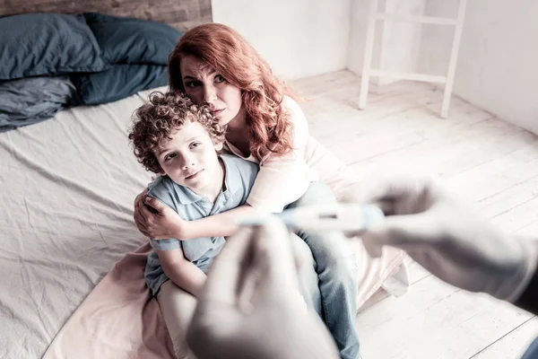 Налякана мати турбується про свого хворого сина — стокове фото