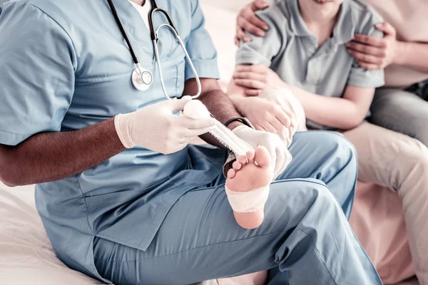 Gros plan du travailleur médical qui met un pansement à pied — Photo