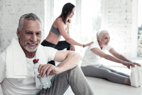 Självsäker äldre man dricksvatten efter gym session — Stockfoto