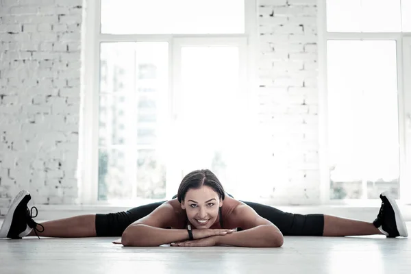 Radiant girl doing splits and smiling — Stock Photo, Image