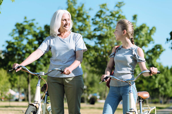 Joyful positive grandmother and granddaughter looking at each other