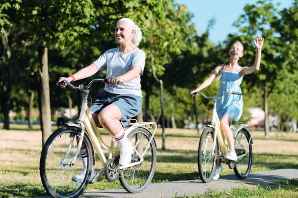 Delighted elderly woman riding a bike