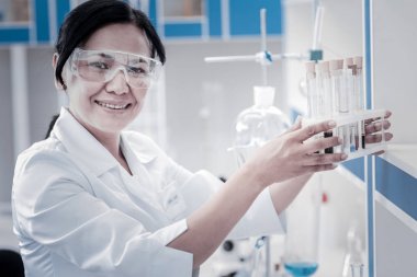 Test tüpleri kümesiyle poz kimyager gülümseyen