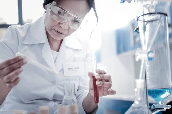Cientista focada misturando líquidos em laboratório — Fotografia de Stock