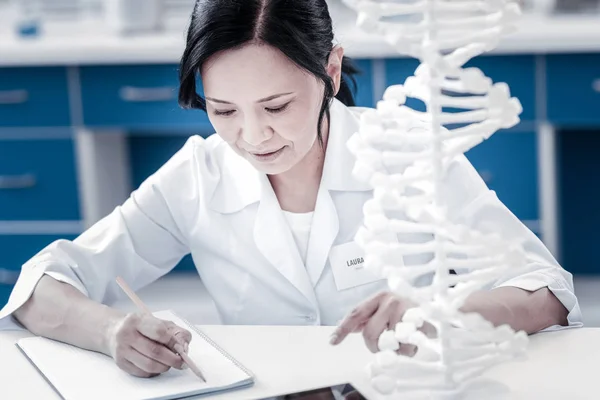 Cientista feminina toma notas enquanto trabalha na pesquisa em saúde — Fotografia de Stock