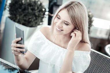 Onun akıllı telefon ekranına bakarak neşeli pozitif kadın