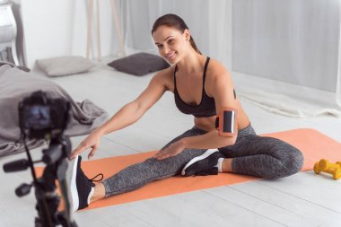 Gülümseyen kas sporcumuz onun blog için egzersizleri yapıyor