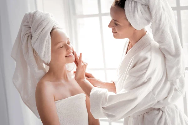 Happy cheerful woman cleaning her daughters face — Stock Photo, Image