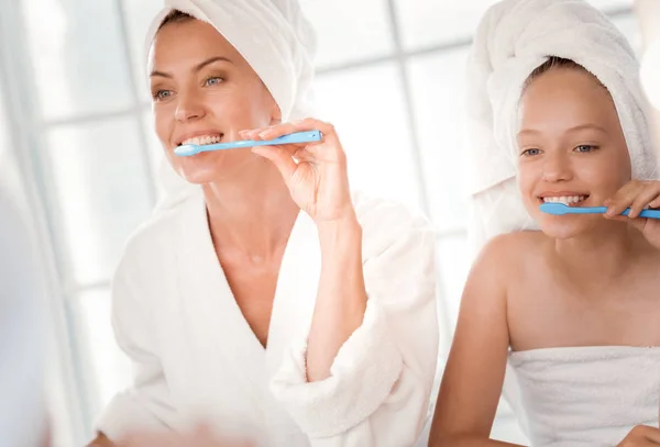 Feliz madre alegre e hija cepillándose los dientes juntos —  Fotos de Stock