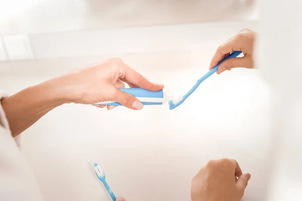 Primer plano de la pasta de dientes que se pone en el cepillo de dientes — Foto de Stock